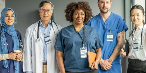 A diverse group of medical professionals in discussion, smiling and collaborating.