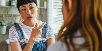 A woman attentively listening and gesturing during a conversation.