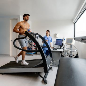 Hombre corriendo en cinta con supervisión médica.