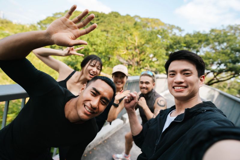 Group of energetic runners jogging together in sync, full of enthusiasm, while their club leader running alongside them, holding a camera to capture the moment and document the club's vibrant spirit