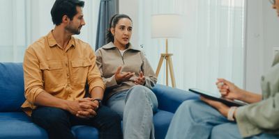 A couple discussing their feelings with a therapist in a cozy room.