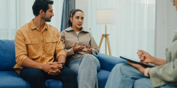 Couple discussing with a therapist in a counseling session.