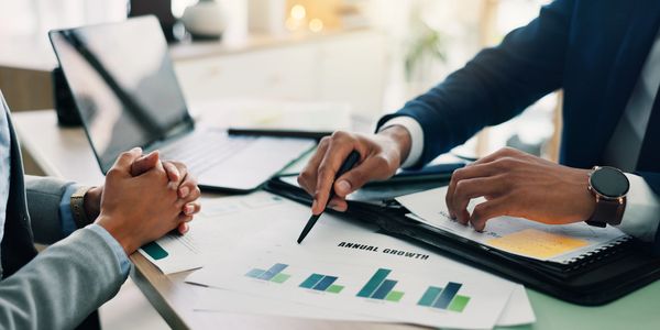 Two professionals discussing annual growth charts in a business meeting.