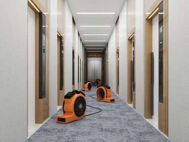 Row of orange air movers in a narrow hallway.