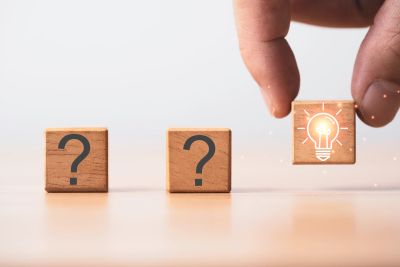 Wooden blocks with question marks and a light bulb icon.