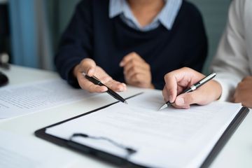 People reviewing and signing documents.