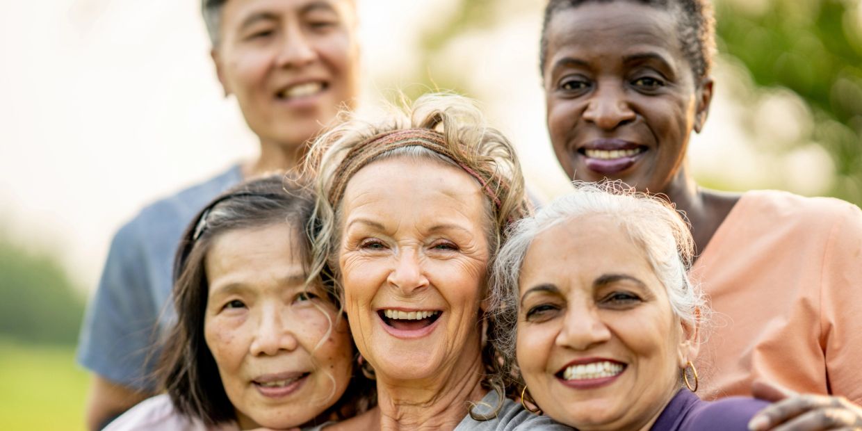 Smiling diverse group of older adults outdoors.
