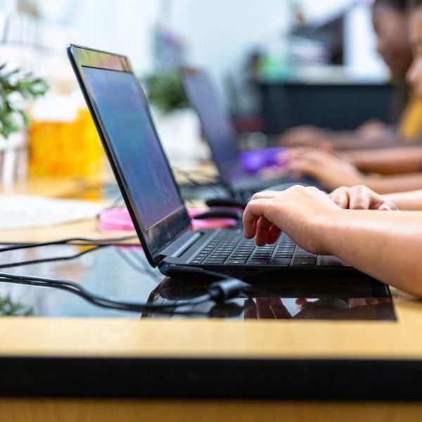People typing on laptops in a focused work environment.