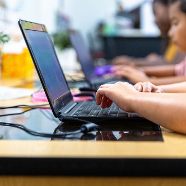 People typing on laptops in a focused work environment.