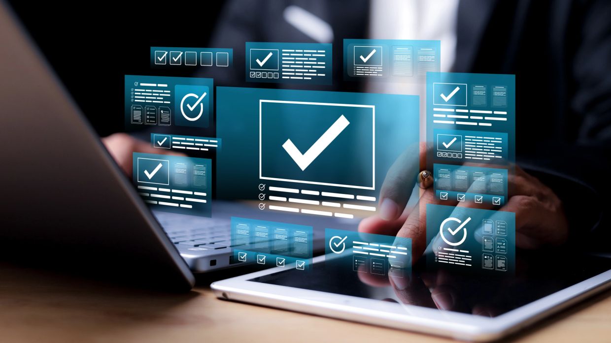 Digital checkmarks floating over laptop and tablet screens.