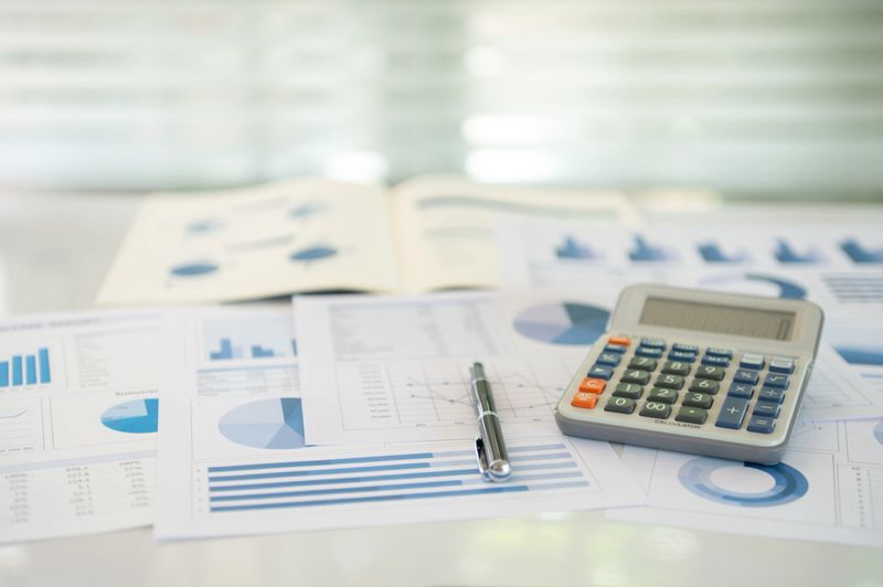 calculator, account statement and business report with review of year end reports. accounting business audit concept.