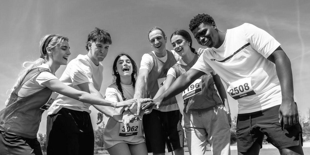 Group of runners or joggers during a workout or training session high fiving and encouraging each ot