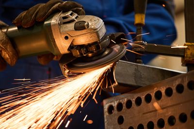 person using a grinder using safe working practices in accordance with PUWER, HSE