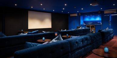 Cozy home theater with plush seating and a large screen.