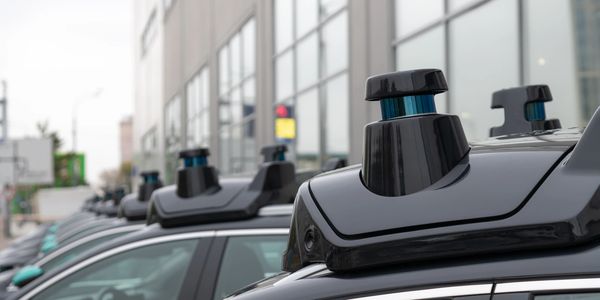 Row of cars equipped with autonomous driving sensors on the roof.