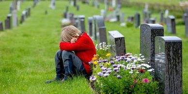 A kid in a graveyard, but not a fun spooky one. 