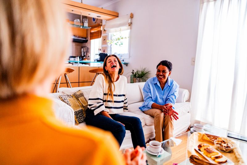 Friends enjoying conversation over afternoon tea in a cozy home setting