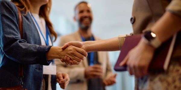 Two people shaking hands during a business event.