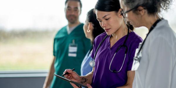 Medical team reviewing patient information on a tablet.