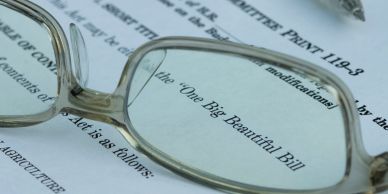 Eyeglasses resting on a document titled 'One Big Beautiful Bill'.
