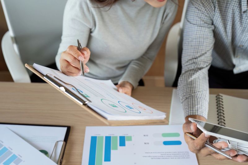Colleagues analyze sustainable business metrics, discussing data-driven strategies in an eco-conscious environment.