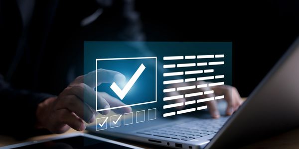 Person interacting with a futuristic digital checklist interface over a laptop keyboard.