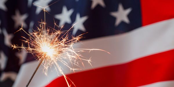 A sparkler burning in front of the American flag.
