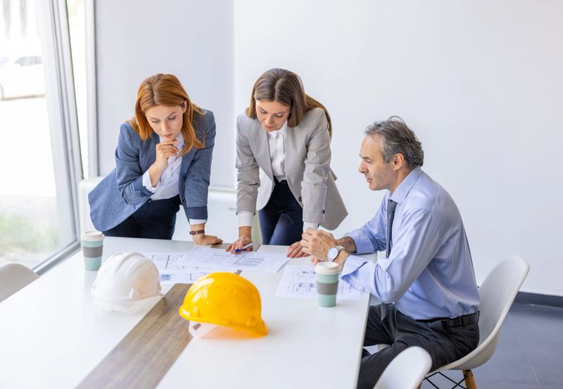 Architects and engineers working together, analyzing blueprints and discussing a project during a productive meeting