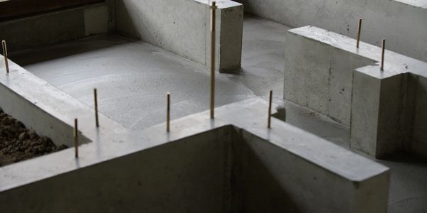 Concrete foundation with embedded rods for structural support.