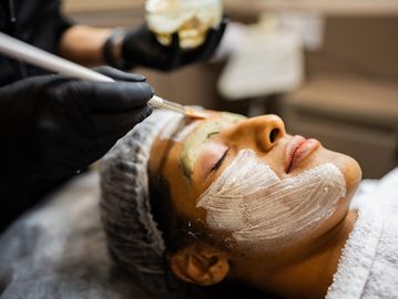 Woman receiving a facial mask treatment.