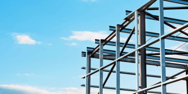 Steel building framework against blue sky.