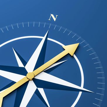 Close-up of a compass rose with a gold needle pointing northeast on a blue background.