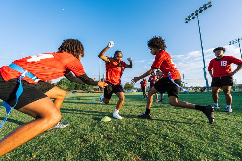 Youth Flag Football Sports Team Bonding and Practicing Together at Sunset in Summer