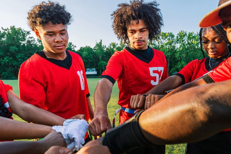 Youth Flag Football Sports Team Bonding and Practicing Together at Sunset in Summer