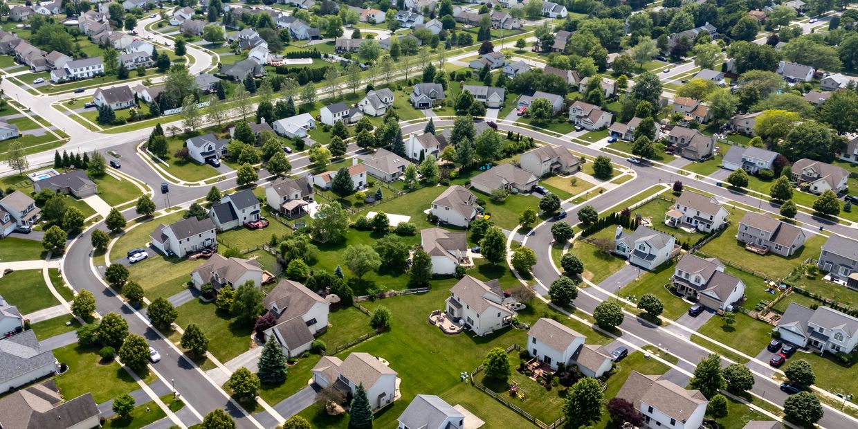 Aerial view of a suburban neighborhood with houses and green lawns.