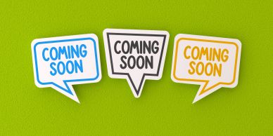 Three signs saying "Coming Soon" on a green background.