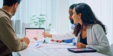 Business team discussing data on a laptop.