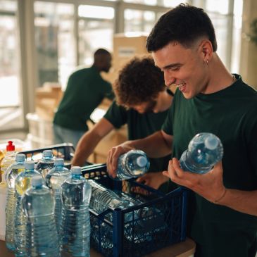 Volunteers sorting and packing bottled water in a bright room.