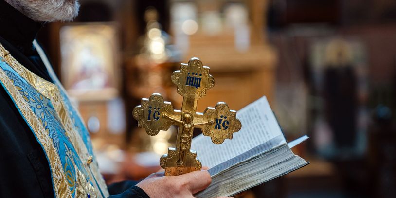Hands holding a communion wafer during a religious ceremony.