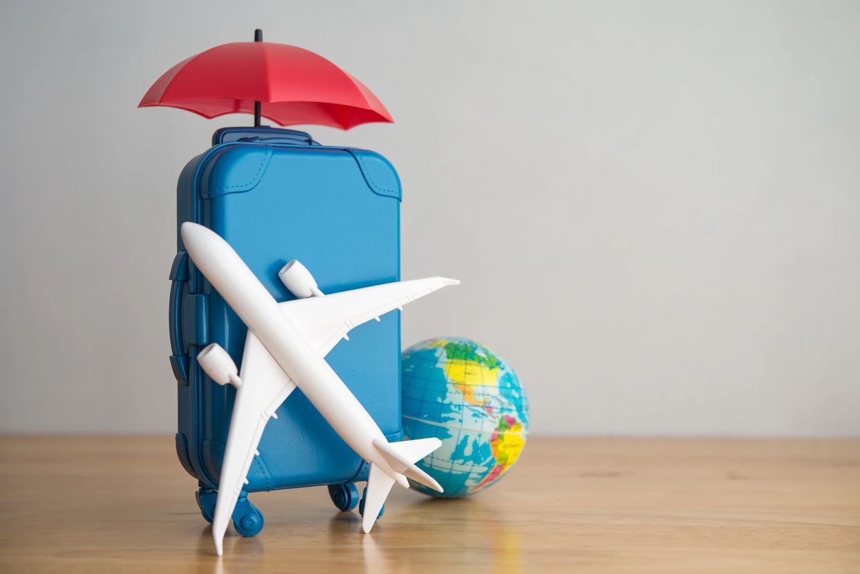 Travel-themed with suitcase, airplane, umbrella, & globe – CPA guidance on deductible travel expense.