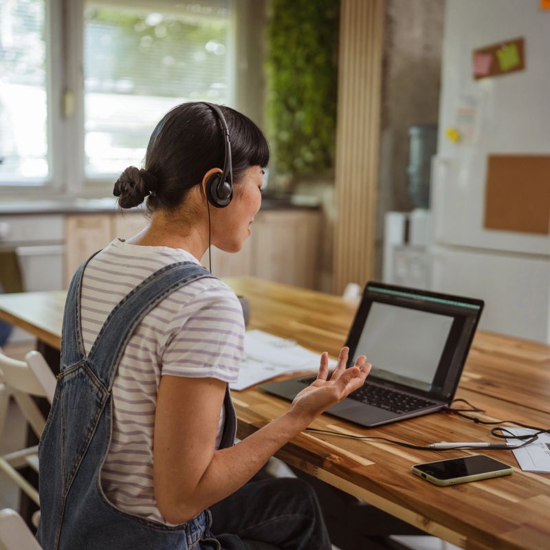 smile japanese woman wearing headset talk on video call with client, work from home concept