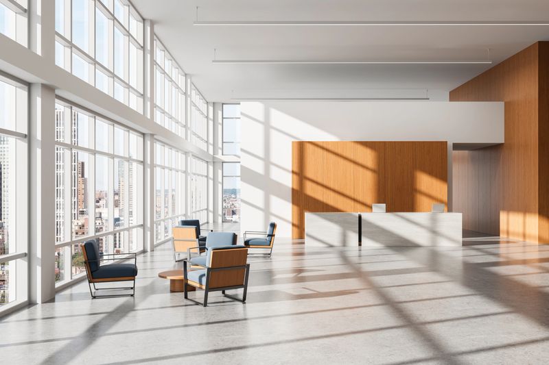 Contemporary office lobby with modern interior design, natural wood accents and furniture, sunlit windows, concrete floor and cityscape view. 3D Rendering