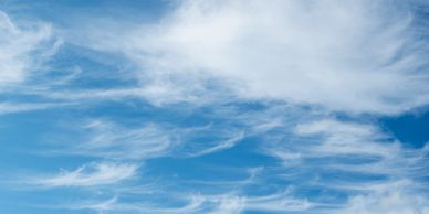 Blue sky with scattered white clouds.