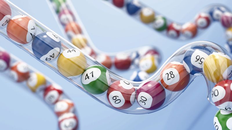 Brightly colored lottery balls move along a curvy track, capturing attention with their vibrant hues. Each ball displays a number, creating an engaging visual spectacle.