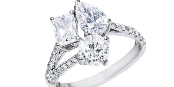 Elegant diamond ring with three distinct stones on a silver band.