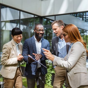 Four business colleagues engaging in a lively discussion outdoors.