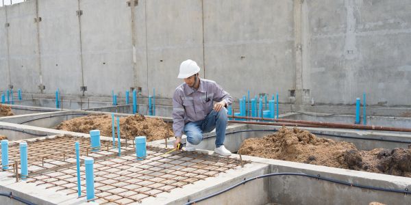 Construction worker measuring at a building site.