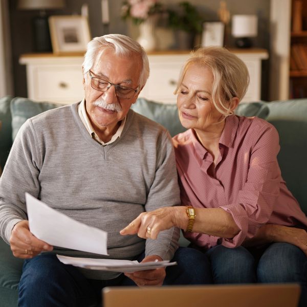 Elderly couple reviewing documents together at home.