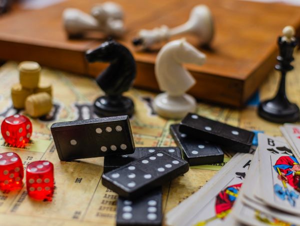 Various board games pieces including dominoes, chess knights, dice, and playing cards.