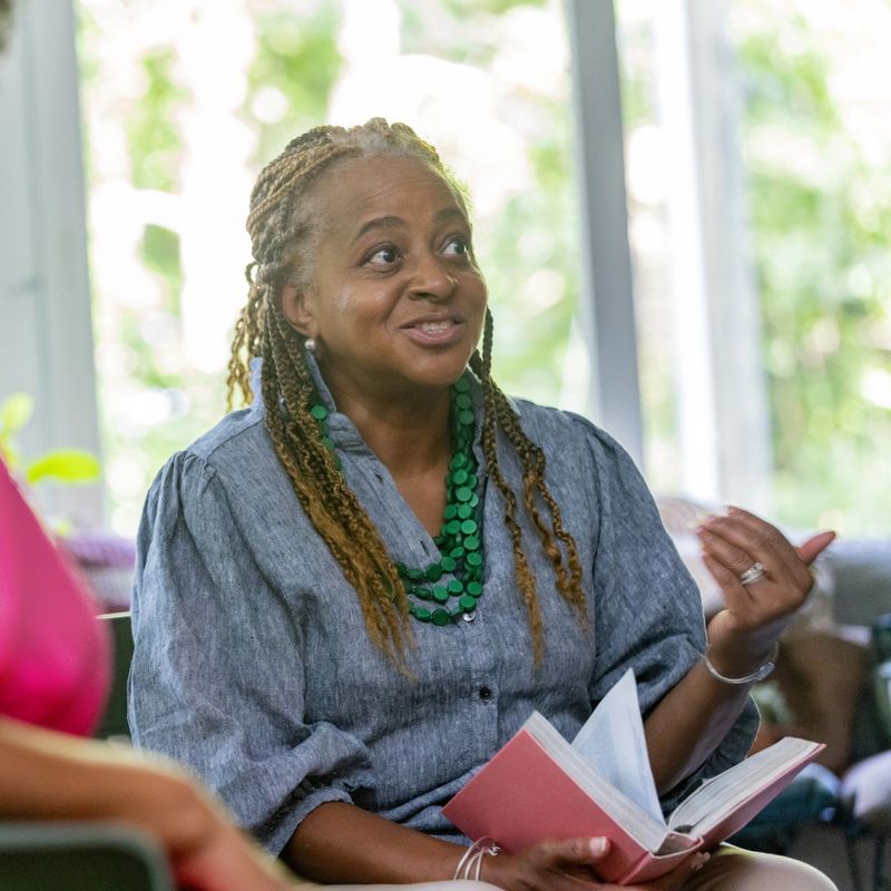 A friendly group enjoys their book discussion in a sun-filled space.